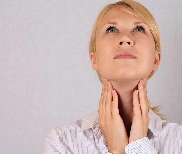 a woman holding her neck feeling her glands