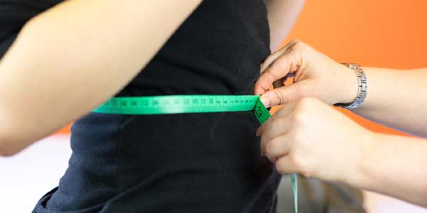 A woman having her waist measured.